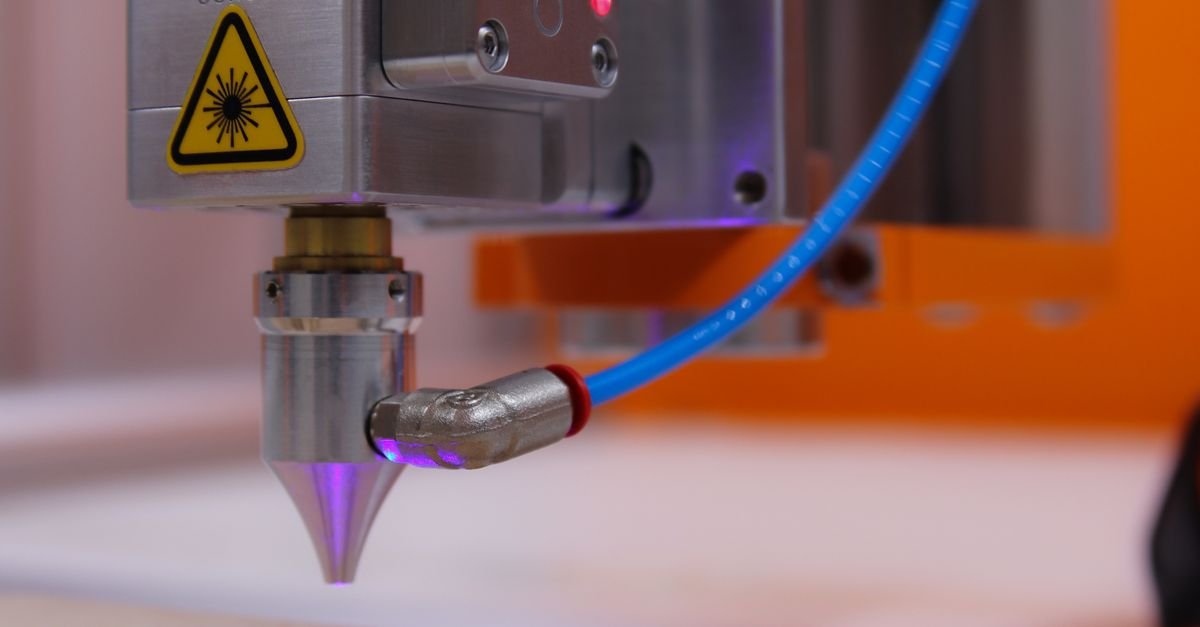 Home High-tech laser engraving machine working on wooden surface.